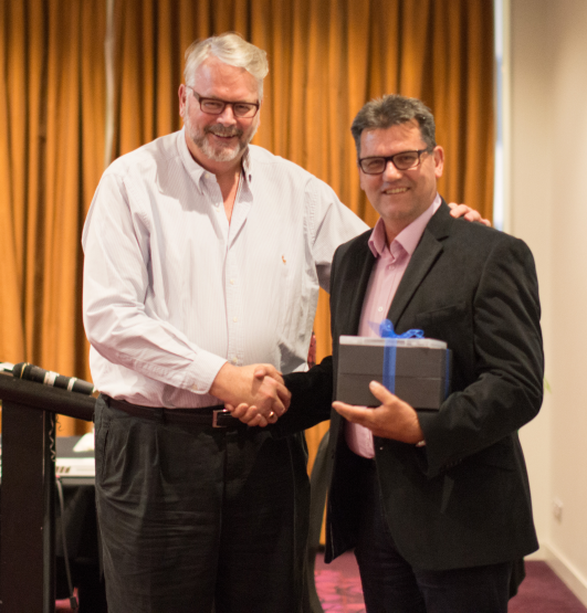 Peter Wade receiving a gift from Greg Whitby.